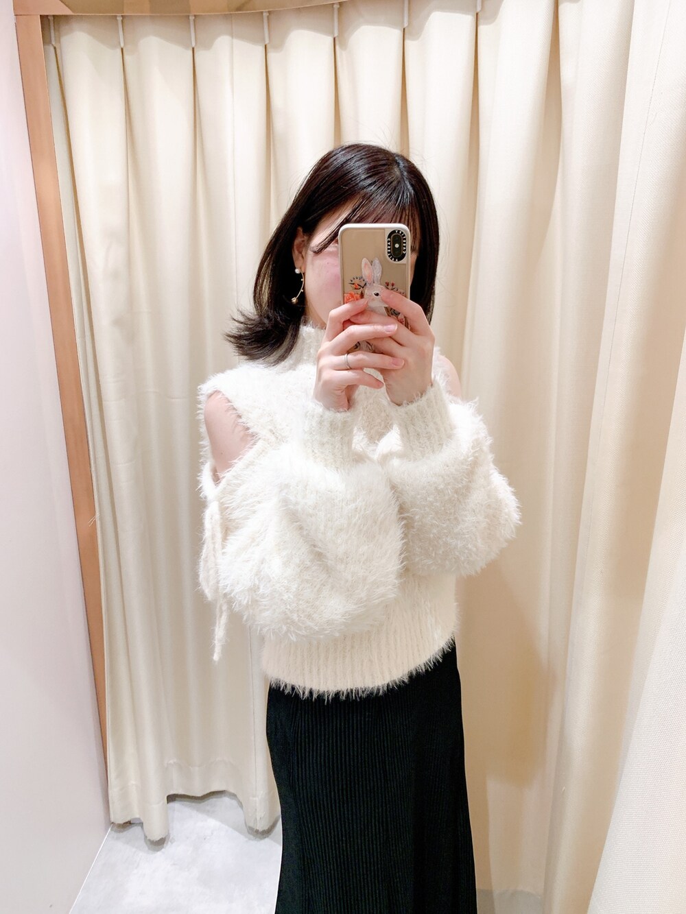 ホワイト系のニット/セーター、ブラック系のスカート、ブラック系のブーツを着用したレディースの冬コーディネートの3枚目の写真