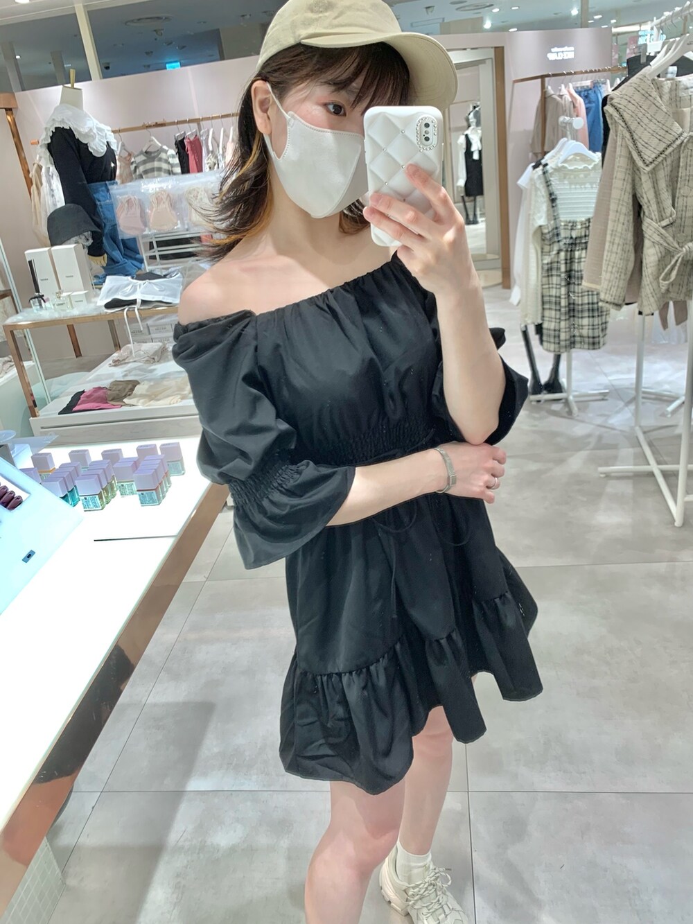ブラック系のチュニック、ホワイト系のボディバッグ/ウエストポーチ、ブルー系のデニムパンツを着用したレディースの春コーディネートの7枚目の写真