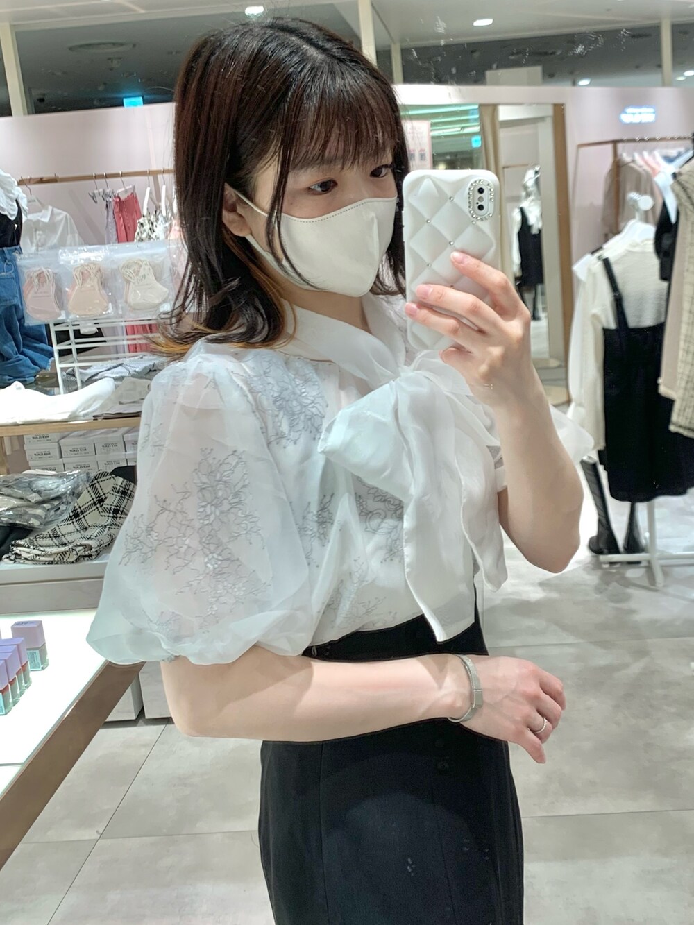 ベージュ系のトレンチコート、ホワイト系のシャツ/ブラウス、ブラック系のショルダーバッグを着用したレディースの春コーディネートの6枚目の写真