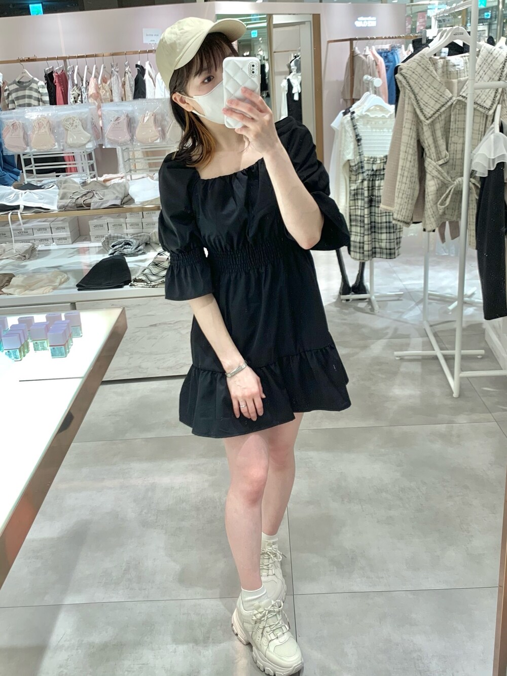 ブラック系のチュニック、ホワイト系のボディバッグ/ウエストポーチ、ブルー系のデニムパンツを着用したレディースの春コーディネートの5枚目の写真