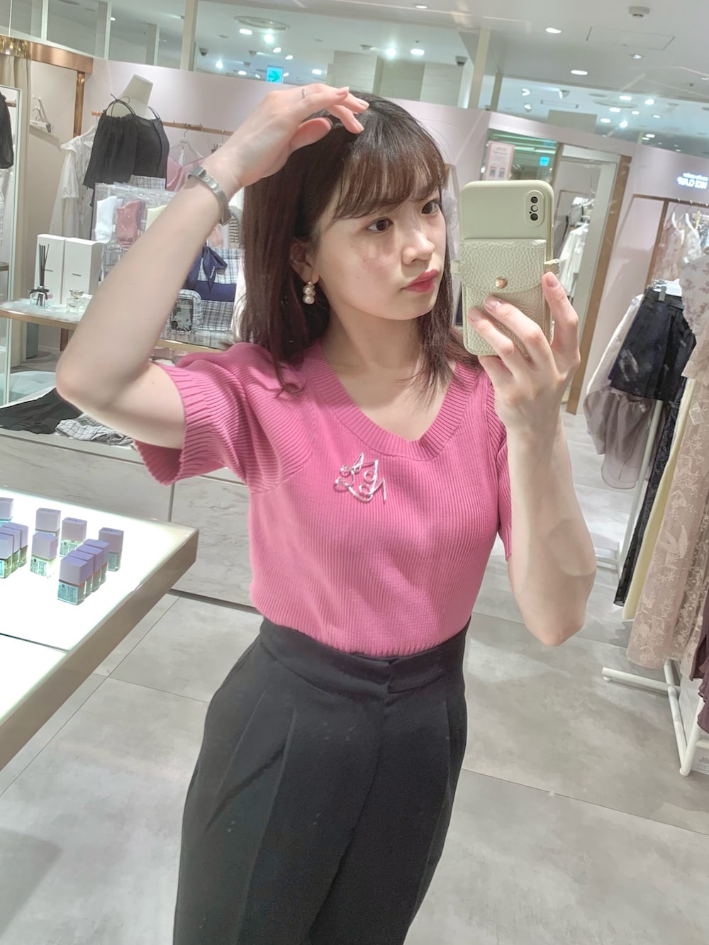 ホワイト系のボストンバッグ、ピンク系のニット/セーター、ブラック系のスラックスを着用したレディースの春コーディネートの6枚目の写真