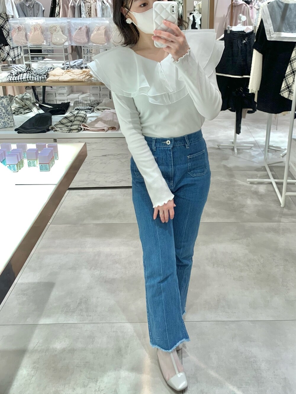 イエロー系のショルダーバッグ、ブルー系のデニムパンツ、グレー系のブーツを着用したレディースの春コーディネートの5枚目の写真