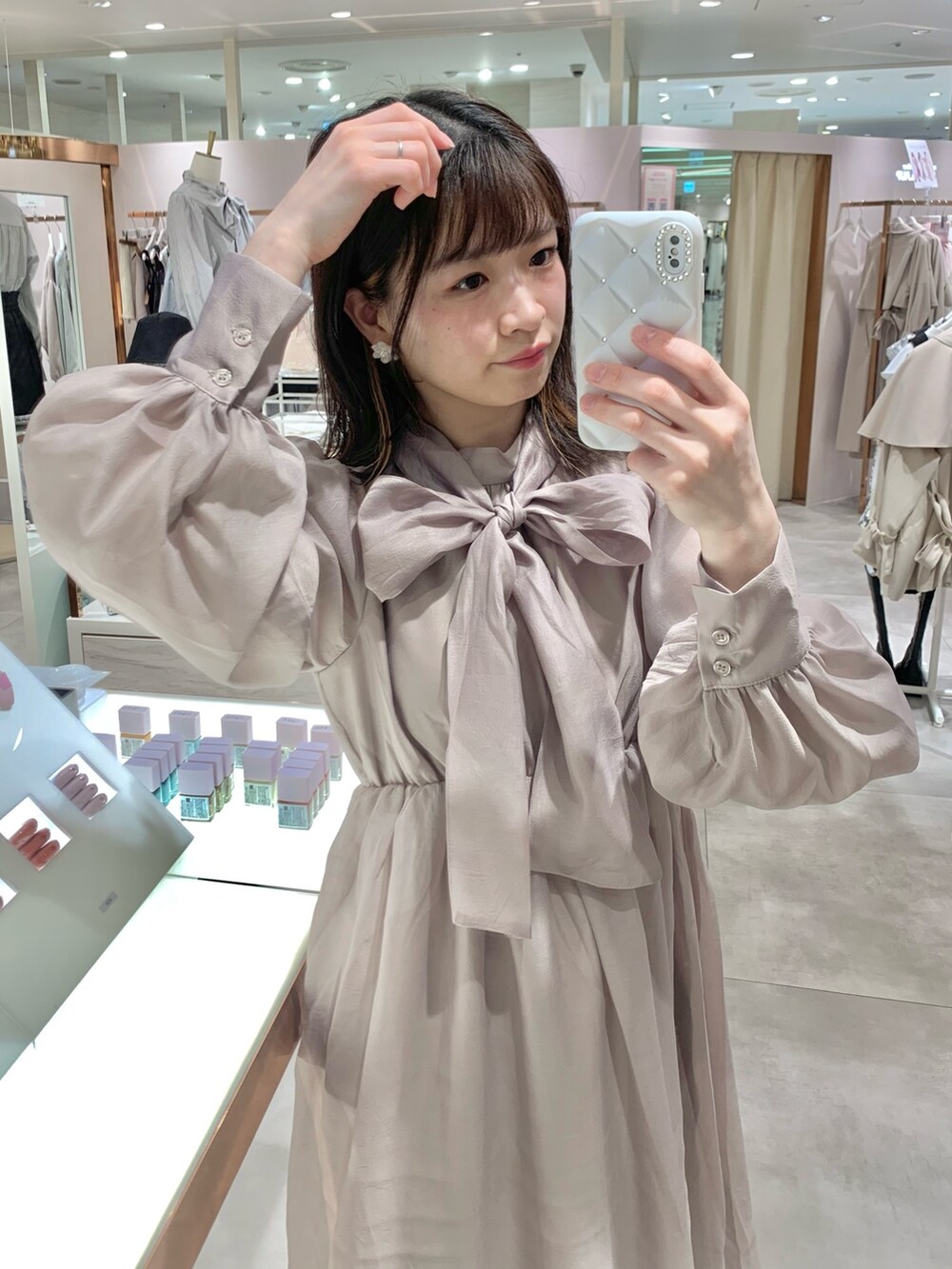 ベージュ系のトレンチコート、ホワイト系のサンダル、ホワイト系のボディバッグ/ウエストポーチを着用したレディースの春コーディネートの6枚目の写真