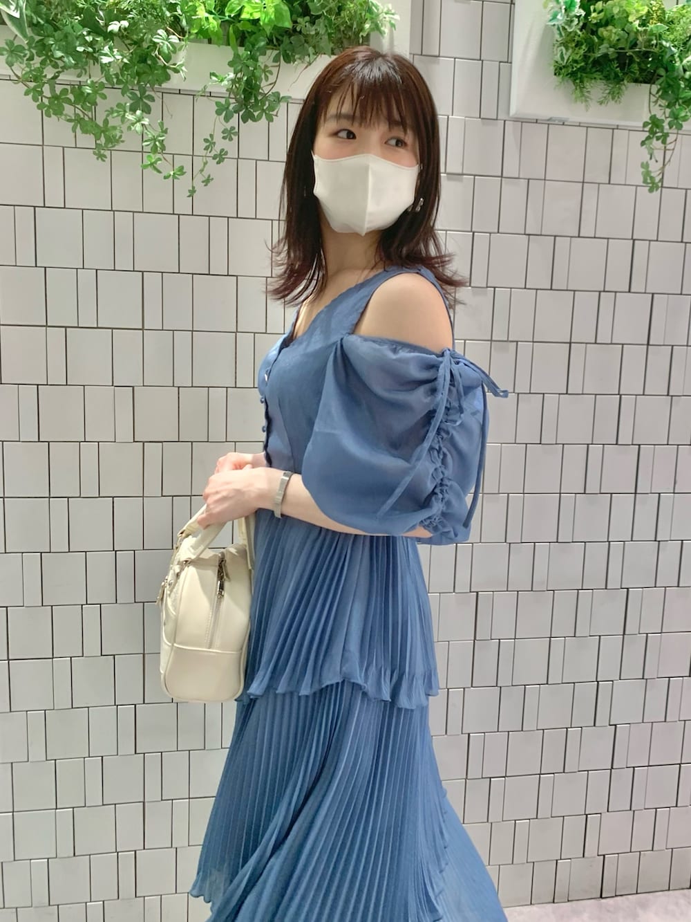 ホワイト系のサンダル、ホワイト系のボストンバッグ、ブルー系のワンピースを着用したレディースの春コーディネートの2枚目の写真