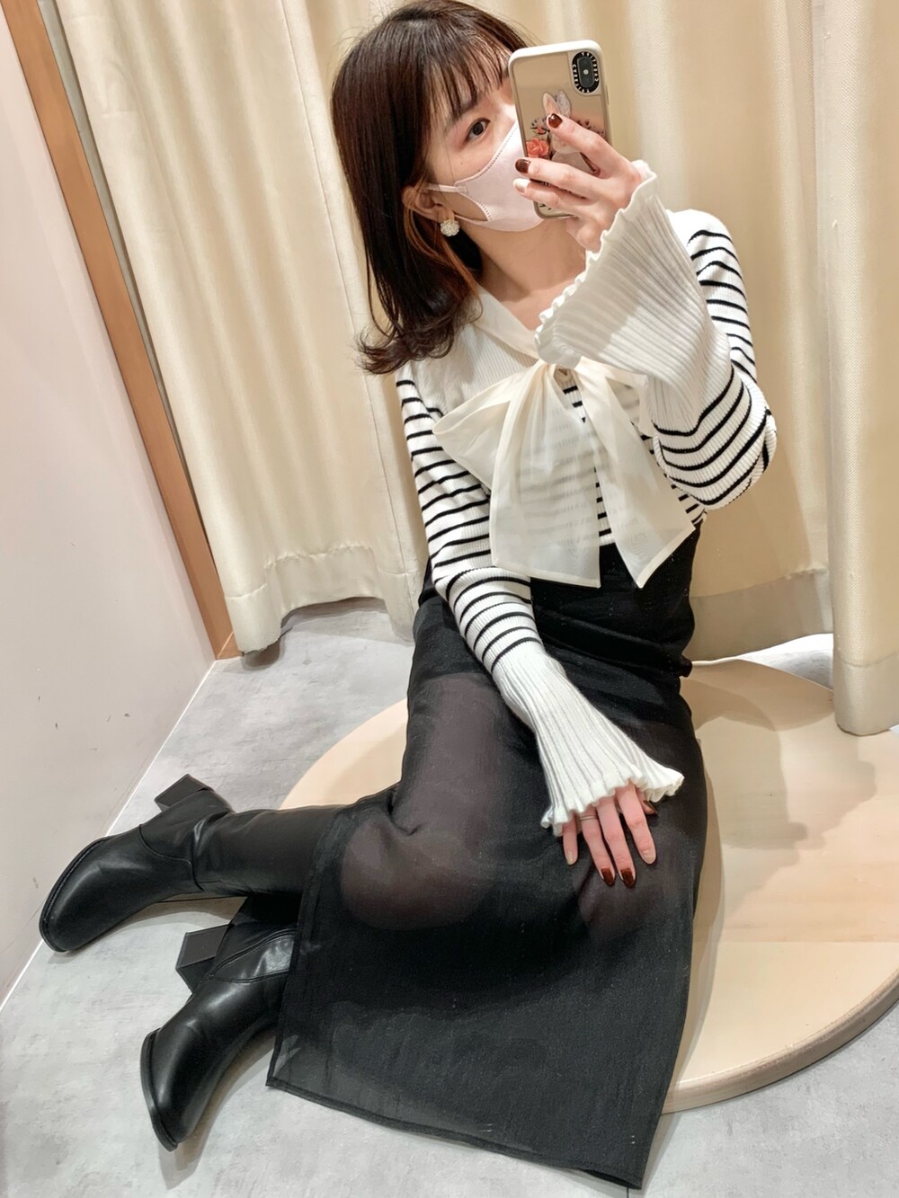 ブラック系のニット/セーター、ブラック系のスカート、ホワイト系のショルダーバッグを着用したレディースの冬コーディネートの3枚目の写真