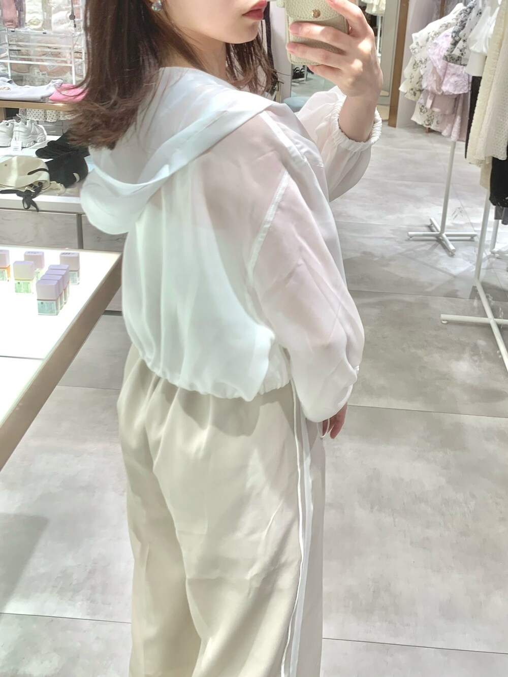 ベージュ系のスラックス、ホワイト系のサンダル、ホワイト系のマウンテンパーカーを着用したレディースの春コーディネートの8枚目の写真