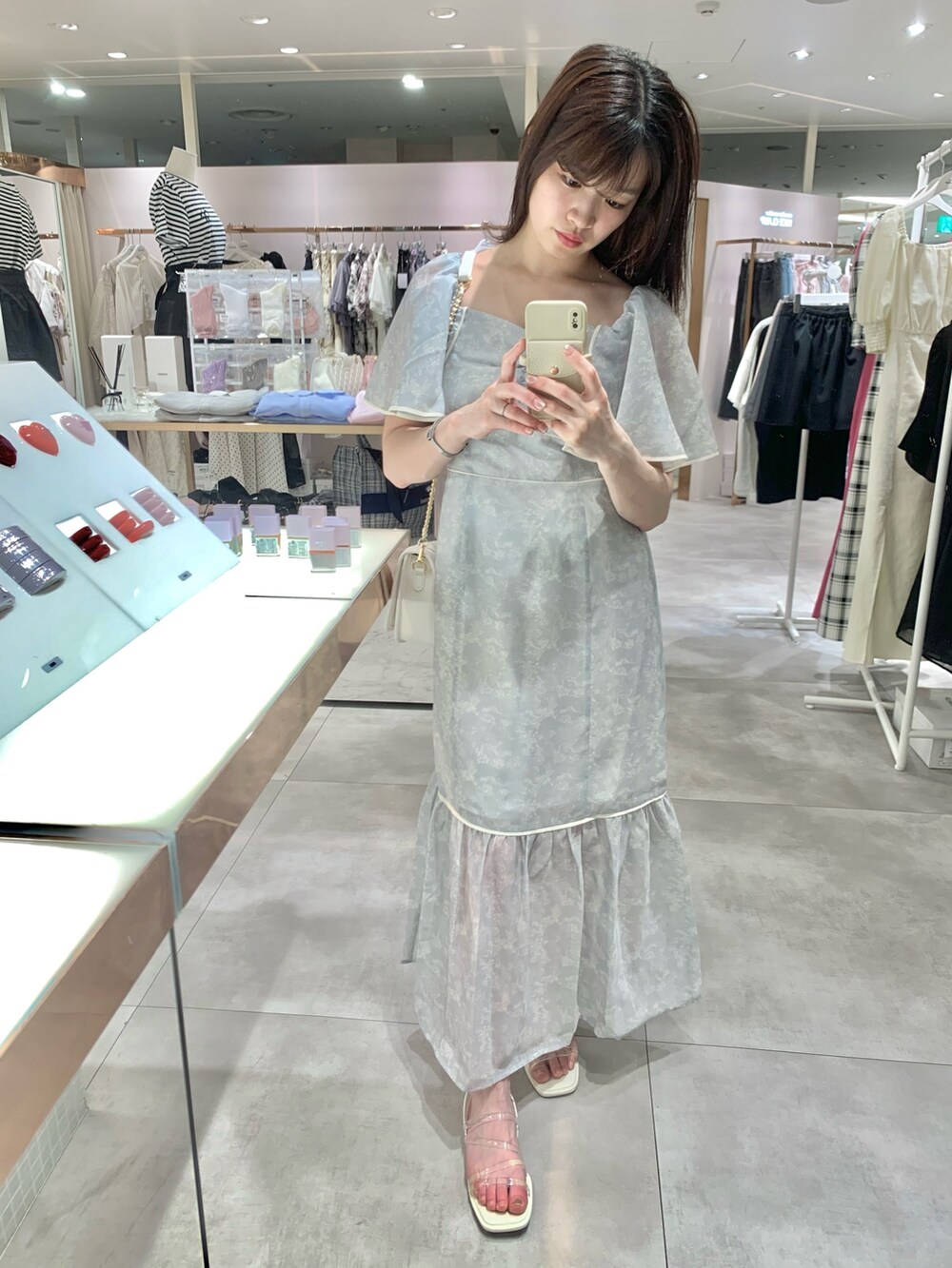 ホワイト系のショルダーバッグ、グレー系のワンピース、ホワイト系のサンダルを着用したレディースの夏コーディネートの2枚目の写真