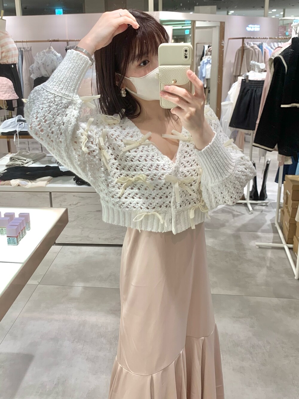 ホワイト系のカーディガン/ボレロ、ホワイト系のボストンバッグ、ピンク系のワンピースを着用したレディースの春コーディネートの6枚目の写真