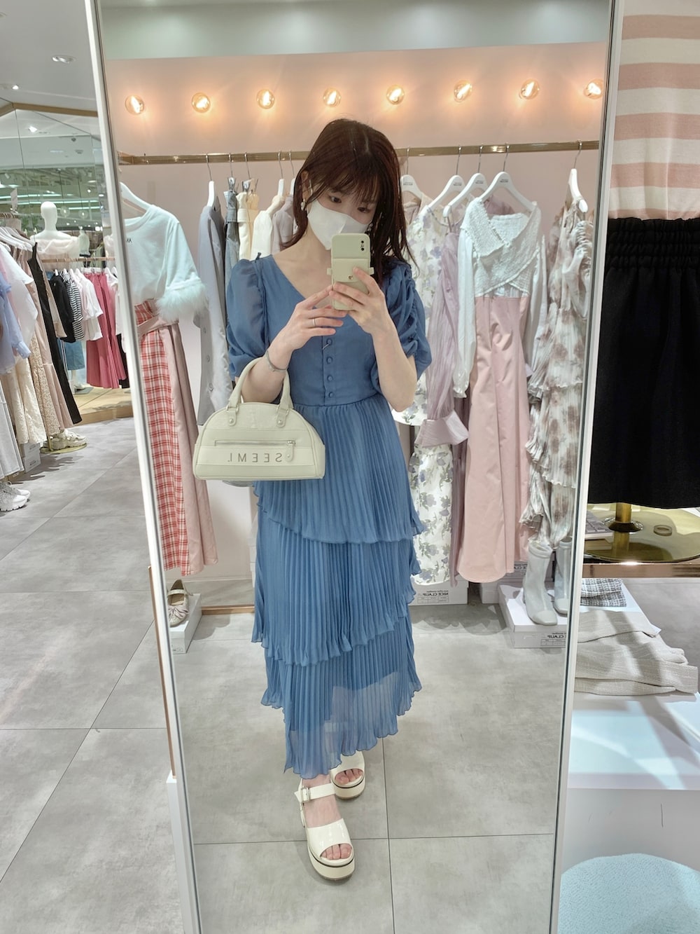 ホワイト系のサンダル、ホワイト系のボストンバッグ、ブルー系のワンピースを着用したレディースの春コーディネートの7枚目の写真