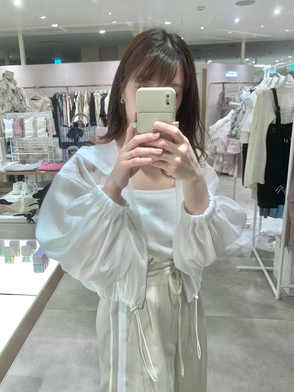 ベージュ系のスラックス、ホワイト系のサンダル、ホワイト系のマウンテンパーカーを着用したレディースの春コーディネートの7枚目の写真