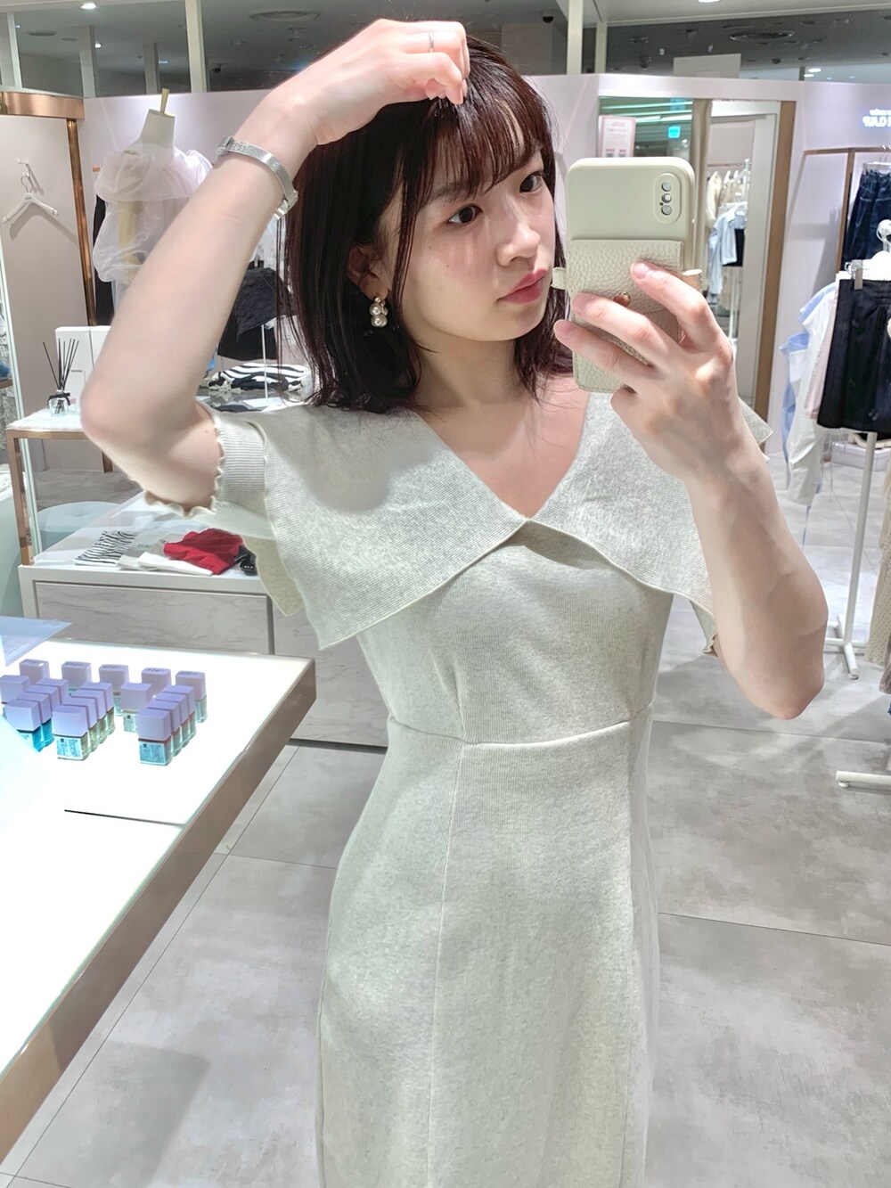 ベージュ系のワンピース、ホワイト系のボストンバッグ、ベージュ系のサンダルを着用したレディースの春コーディネートの6枚目の写真