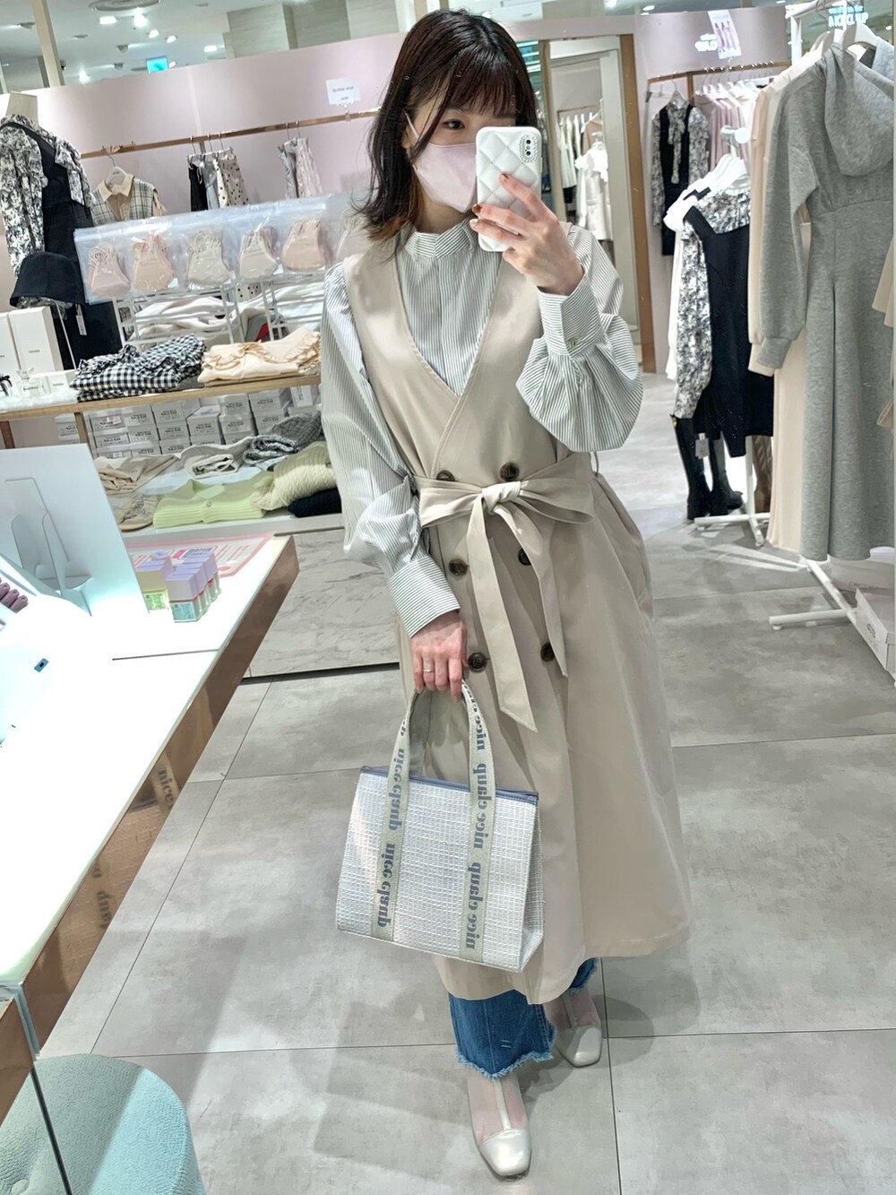 ベージュ系のトレンチコート、グレー系のブーツ、ブルー系のデニムパンツを着用したレディースの春コーディネートの6枚目の写真