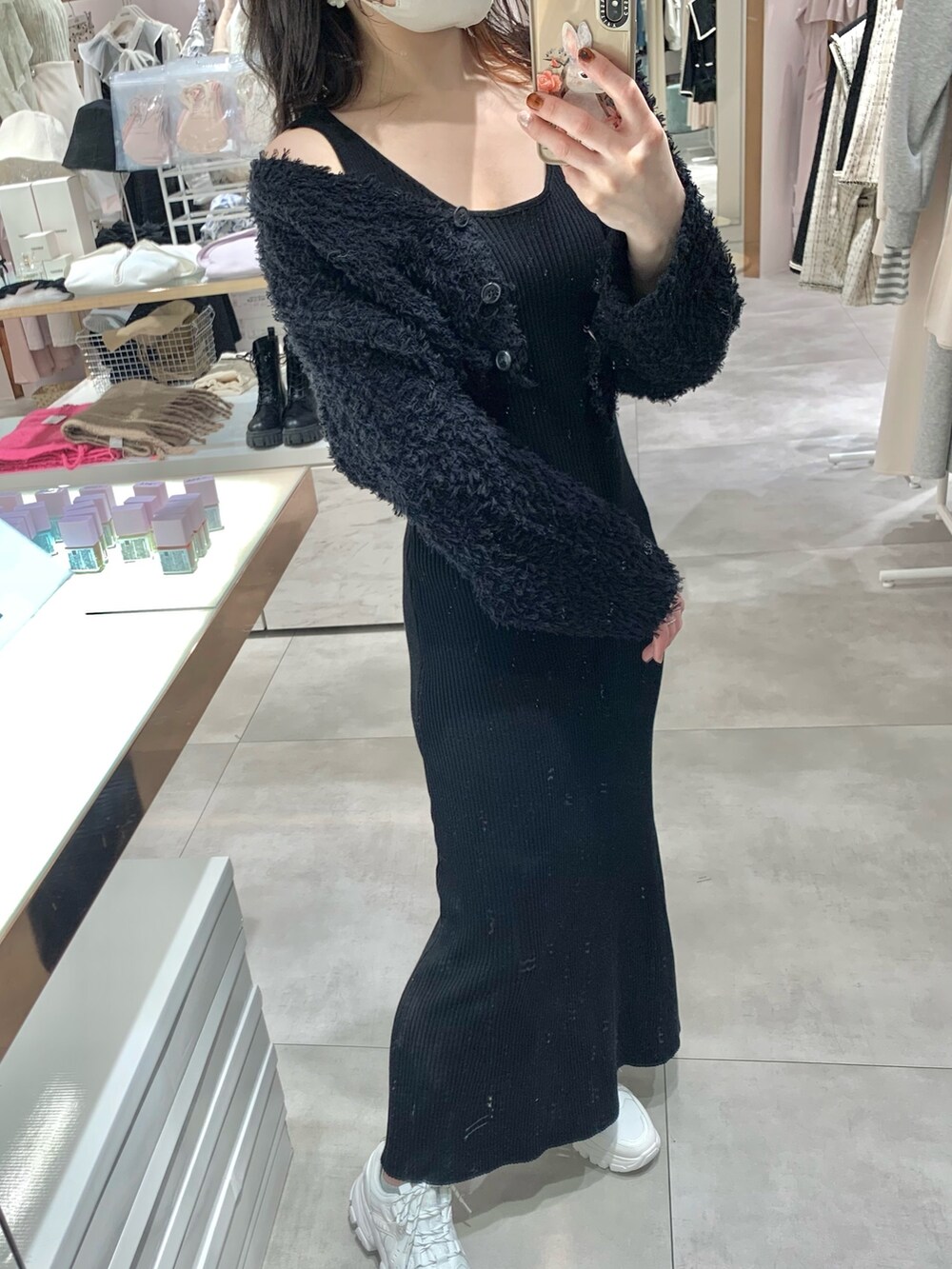 ホワイト系のマウンテンパーカー、ブラック系のワンピース、ホワイト系のスニーカーを着用したレディースの春コーディネートの4枚目の写真