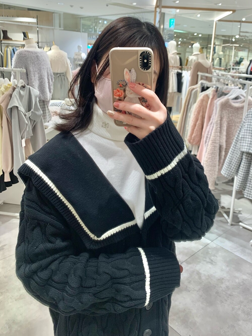 ホワイト系のTシャツ/カットソー、ブラック系のカーディガン/ボレロ、ホワイト系のスカートを着用したレディースの冬コーディネートの2枚目の写真