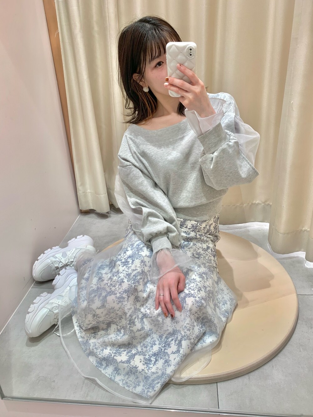 グレー系のスウェット、ホワイト系のボストンバッグ、ブルー系のスカートを着用したレディースの春コーディネートの6枚目の写真