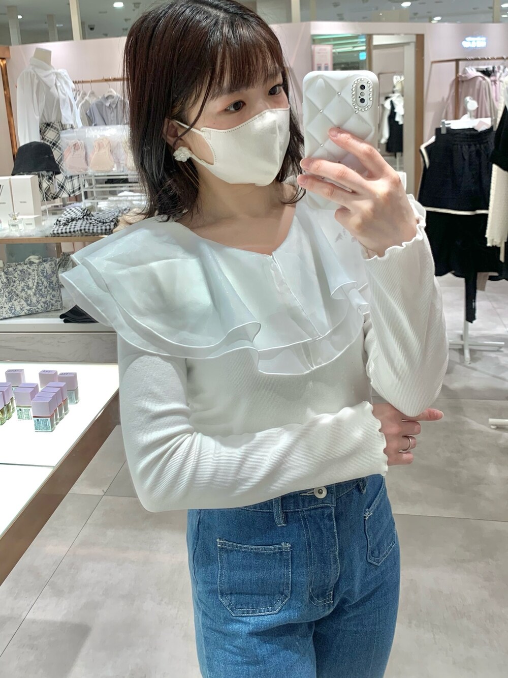 イエロー系のショルダーバッグ、ブルー系のデニムパンツ、グレー系のブーツを着用したレディースの春コーディネートの4枚目の写真