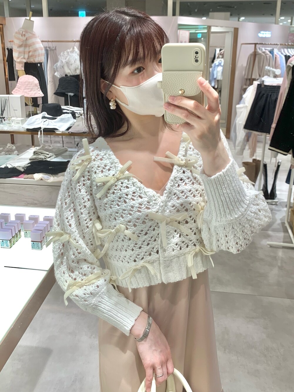 ホワイト系のカーディガン/ボレロ、ホワイト系のボストンバッグ、ピンク系のワンピースを着用したレディースの春コーディネートの5枚目の写真