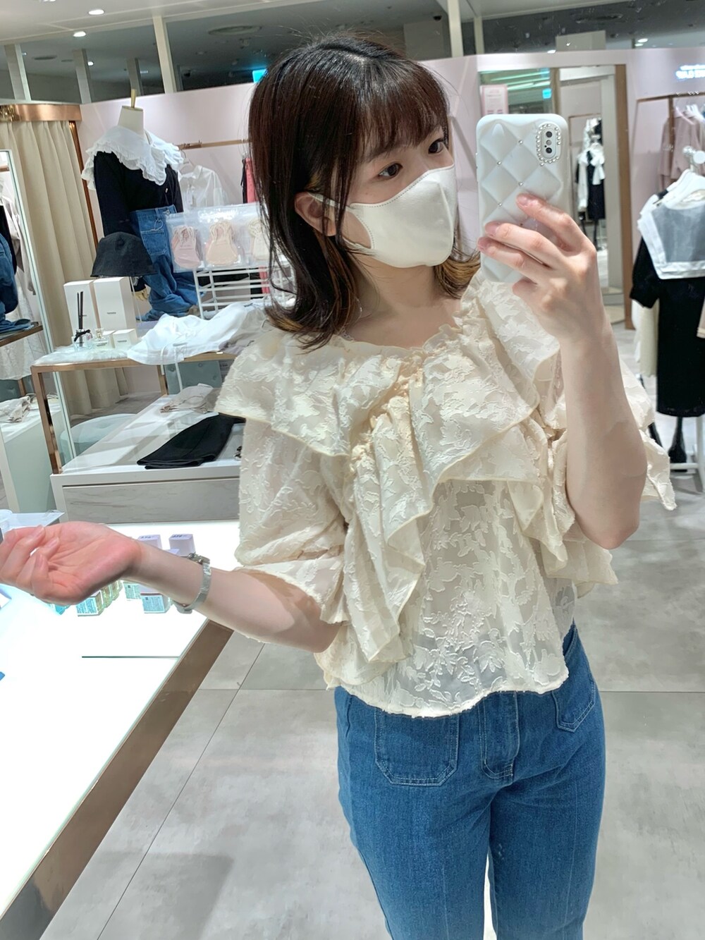 ベージュ系のトレンチコート、ブラック系のショルダーバッグ、ブルー系のデニムパンツを着用したレディースの春コーディネートの6枚目の写真