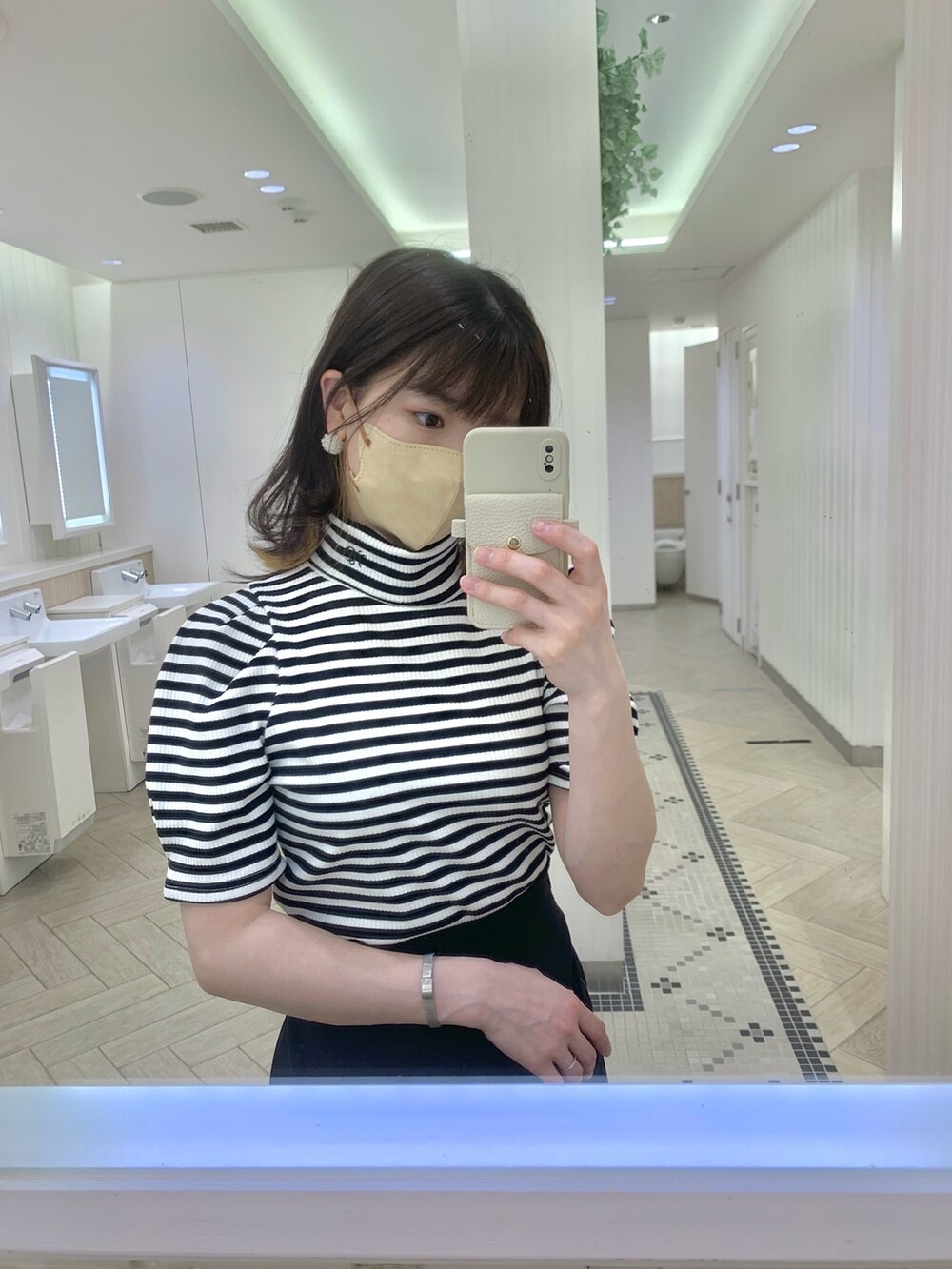 ベージュ系のトレンチコート、ホワイト系のショルダーバッグ、ベージュ系のサンダルを着用したレディースの春コーディネートの5枚目の写真