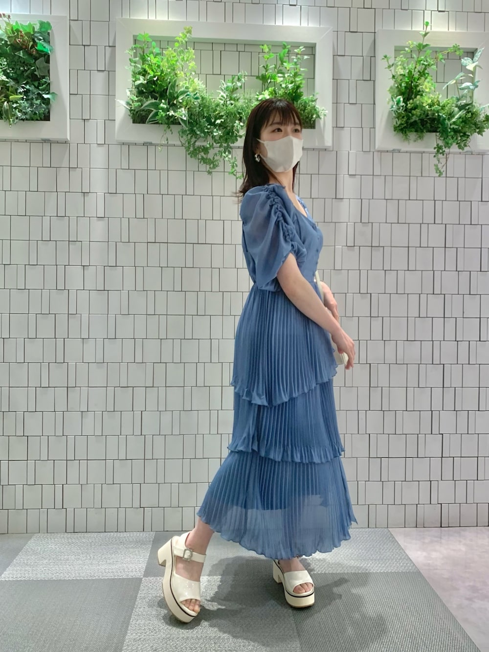 ホワイト系のサンダル、ホワイト系のボストンバッグ、ブルー系のワンピースを着用したレディースの春コーディネートの8枚目の写真