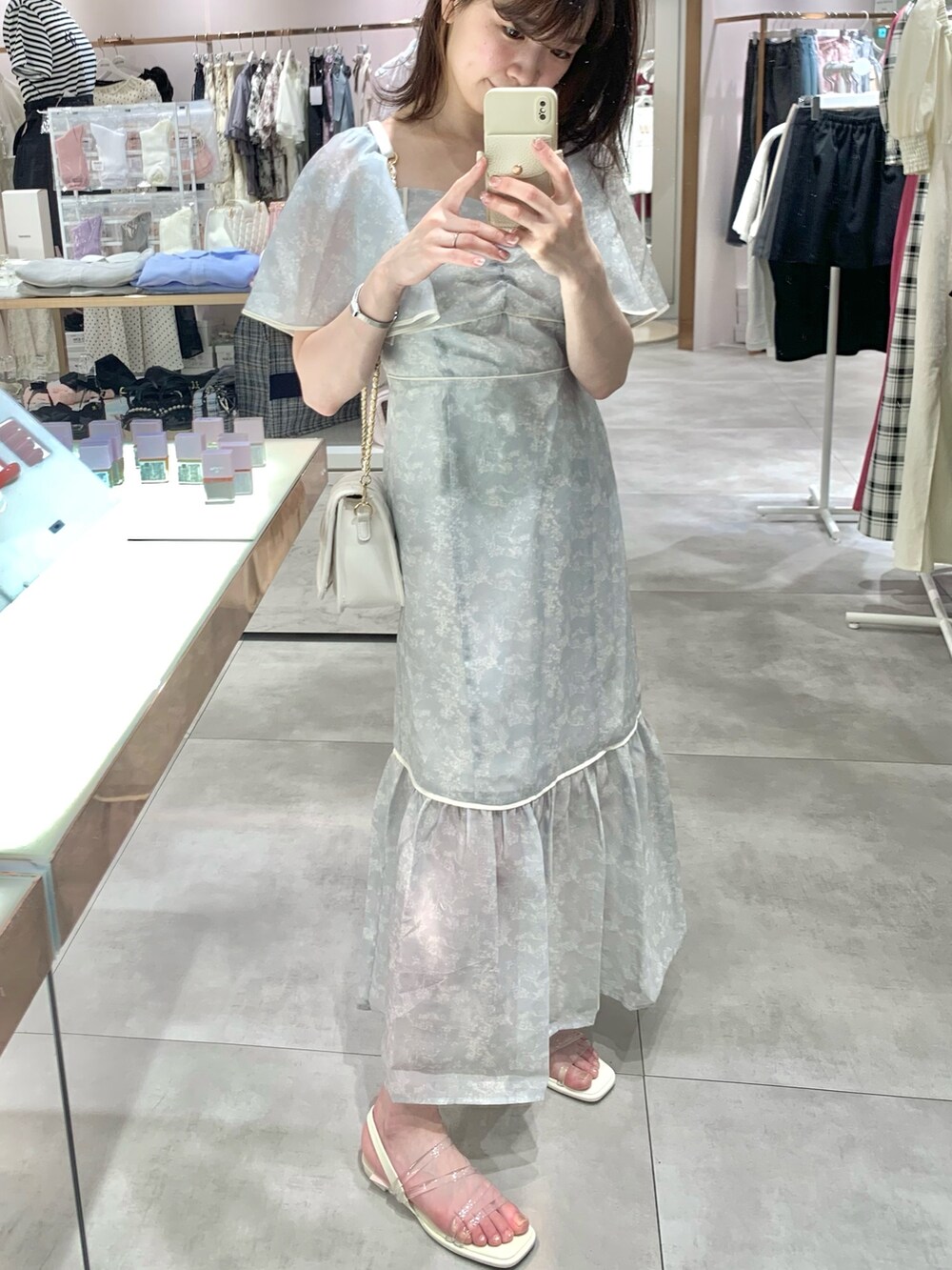 ホワイト系のショルダーバッグ、グレー系のワンピース、ホワイト系のサンダルを着用したレディースの夏コーディネートの5枚目の写真