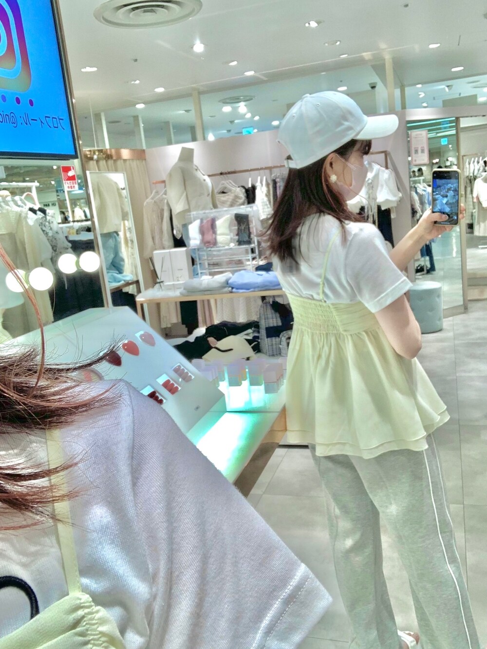 ホワイト系のTシャツ/カットソー、ホワイト系のサンダル、イエロー系のキャミソールを着用したレディースの春コーディネートの5枚目の写真