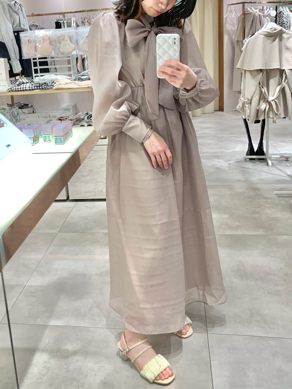 ベージュ系のトレンチコート、ホワイト系のサンダル、ホワイト系のボディバッグ/ウエストポーチを着用したレディースの春コーディネートの9枚目の写真