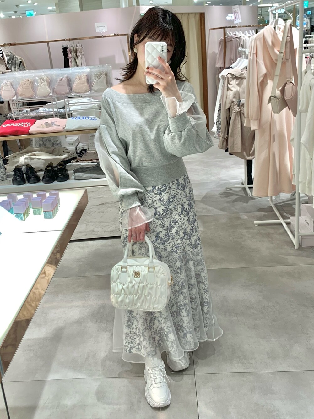 グレー系のスウェット、ホワイト系のボストンバッグ、ブルー系のスカートを着用したレディースの春コーディネートの5枚目の写真
