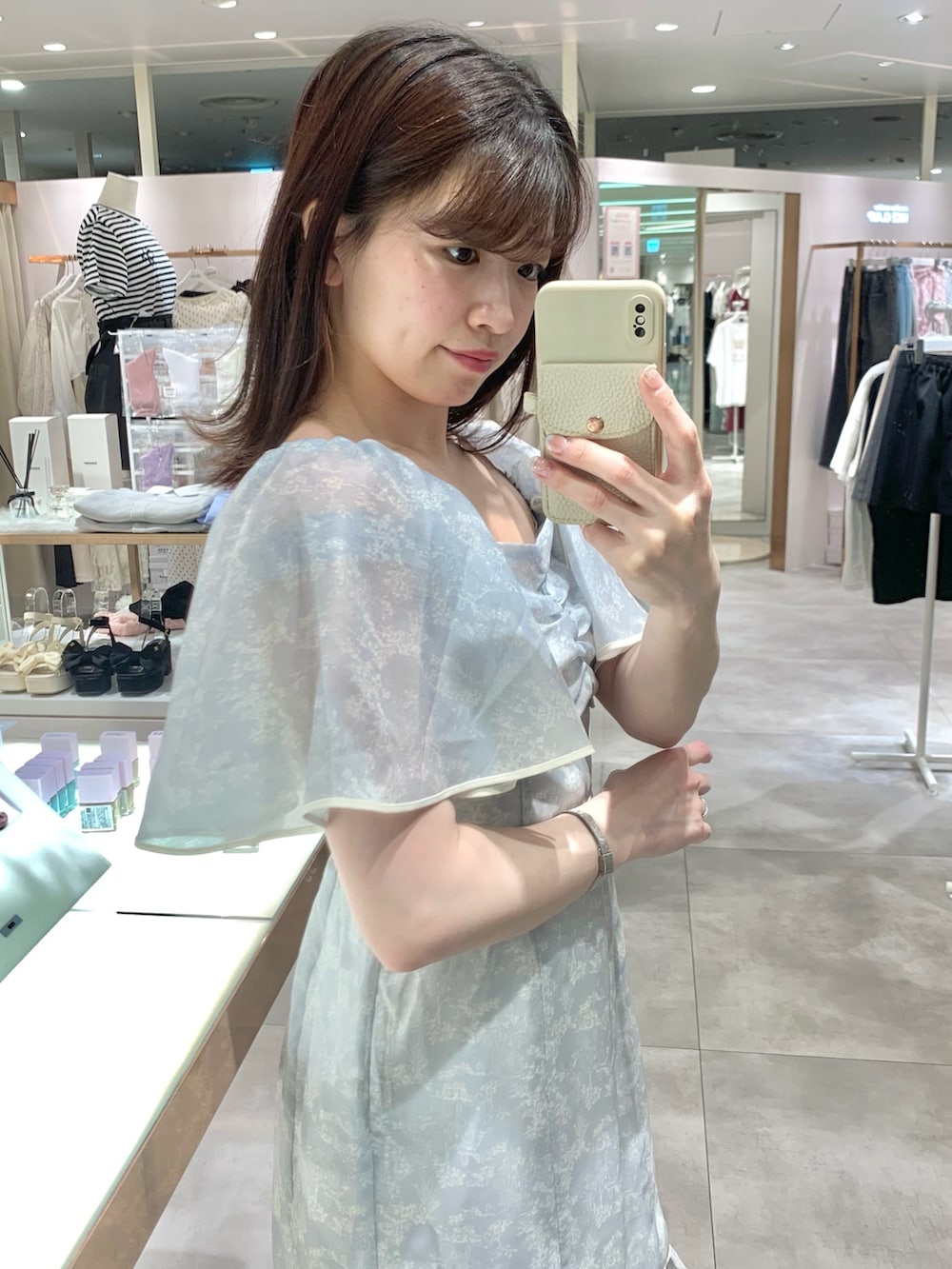 ホワイト系のショルダーバッグ、グレー系のワンピース、ホワイト系のサンダルを着用したレディースの夏コーディネートの3枚目の写真