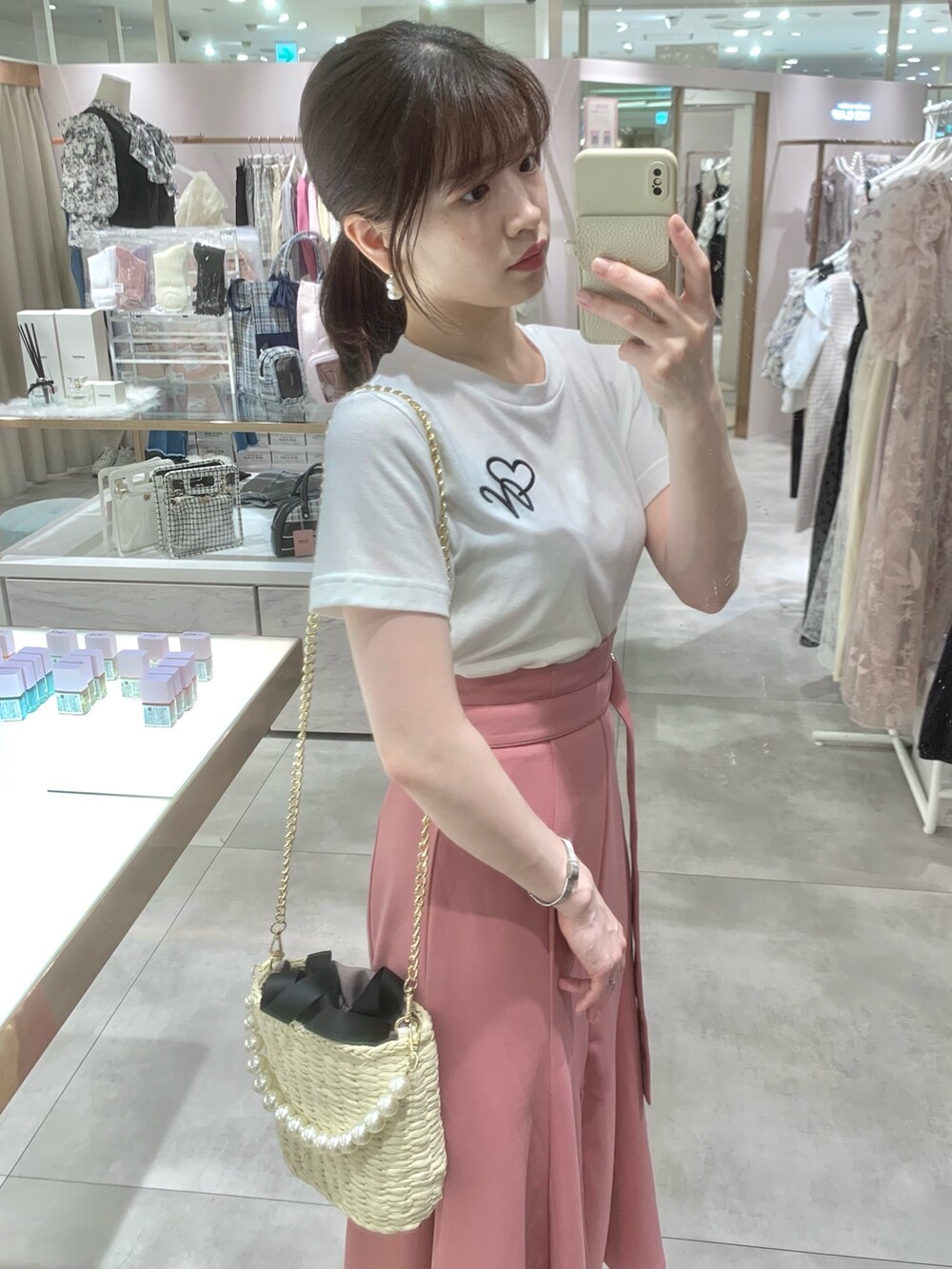 ホワイト系のTシャツ/カットソー、ブラック系のかごバッグ、ホワイト系のサンダルを着用したレディースの春コーディネートの3枚目の写真