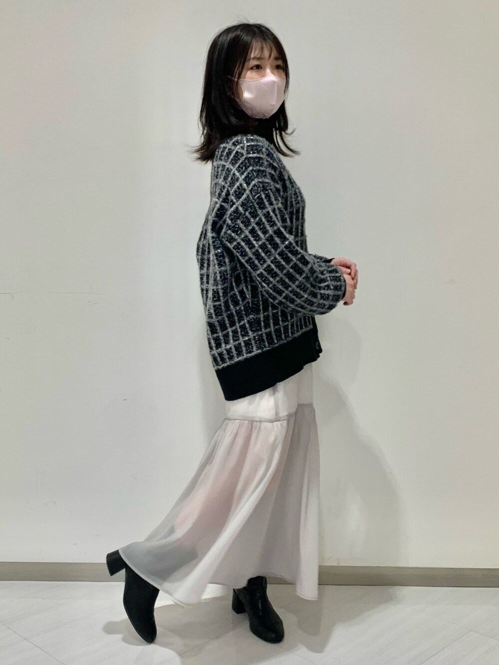 ブラック系のカーディガン/ボレロ、グレー系のスカート、ブラック系のブーツを着用したレディースの冬コーディネートの6枚目の写真