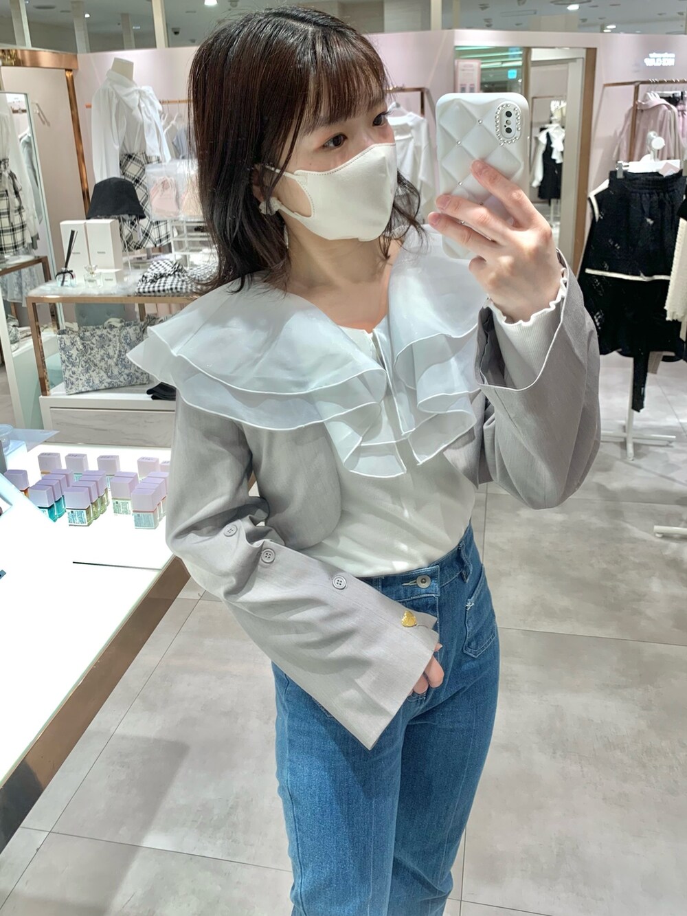 イエロー系のショルダーバッグ、ブルー系のデニムパンツ、グレー系のブーツを着用したレディースの春コーディネートの3枚目の写真