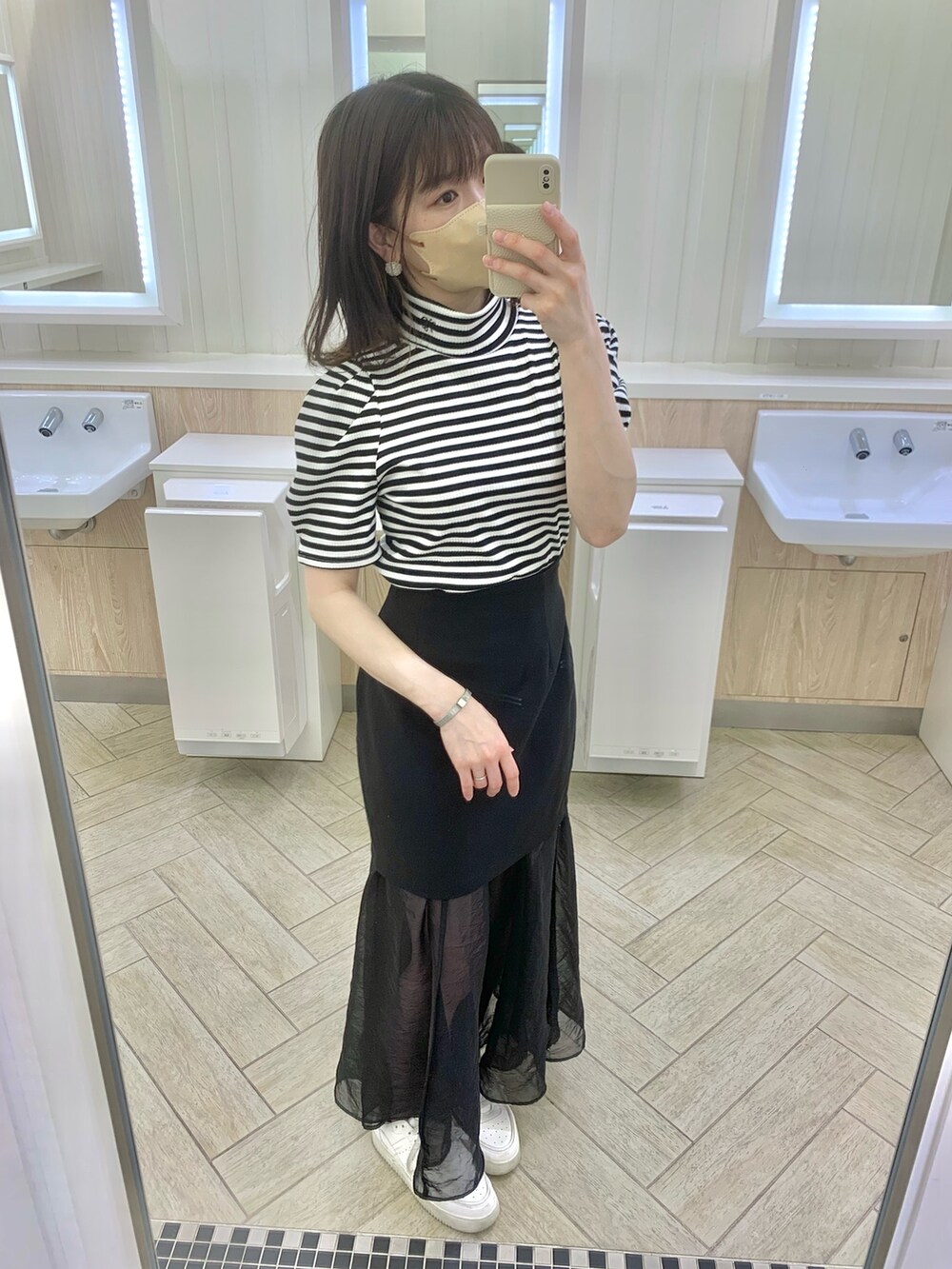 ベージュ系のトレンチコート、ホワイト系のショルダーバッグ、ベージュ系のサンダルを着用したレディースの春コーディネートの4枚目の写真
