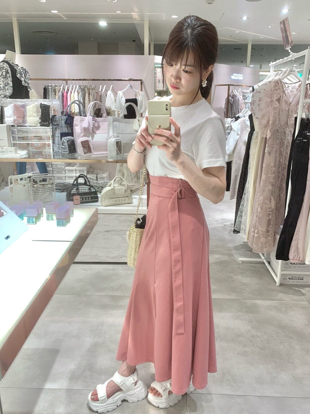 ホワイト系のTシャツ/カットソー、ブラック系のかごバッグ、ホワイト系のサンダルを着用したレディースの春コーディネートの5枚目の写真