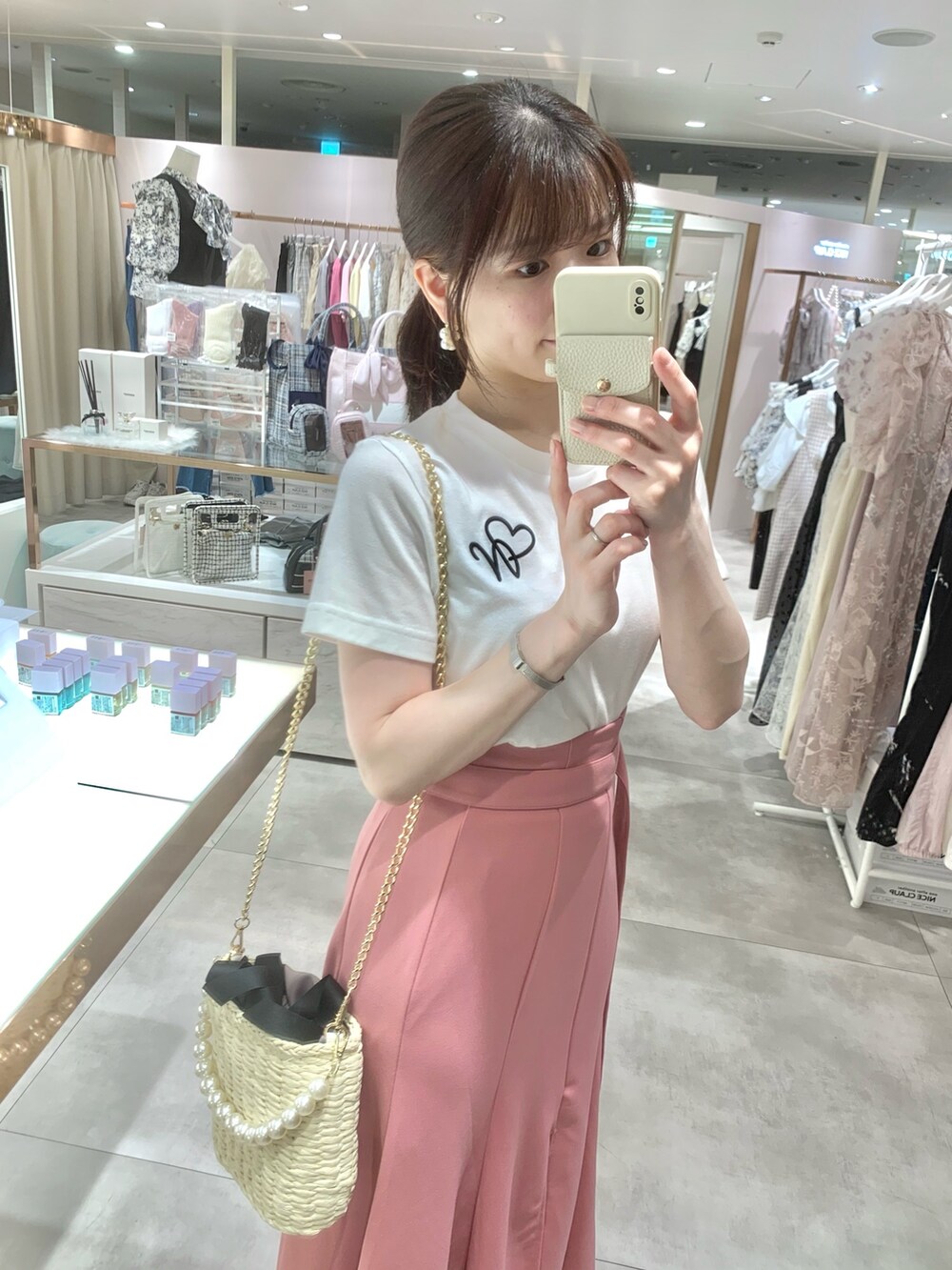 ホワイト系のTシャツ/カットソー、ブラック系のかごバッグ、ホワイト系のサンダルを着用したレディースの春コーディネートの4枚目の写真