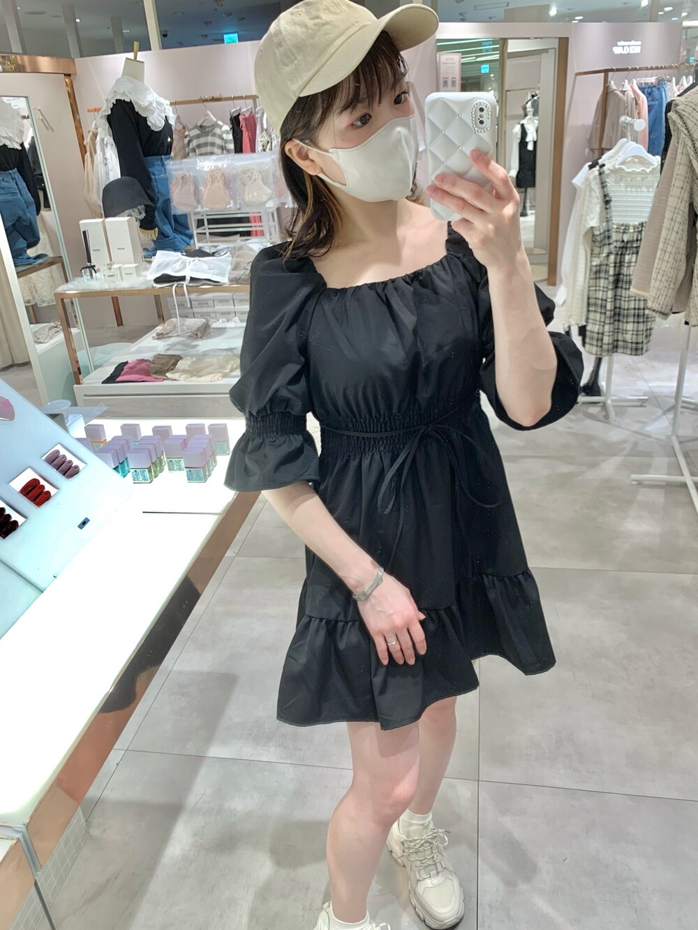 ブラック系のチュニック、ホワイト系のボディバッグ/ウエストポーチ、ブルー系のデニムパンツを着用したレディースの春コーディネートの4枚目の写真