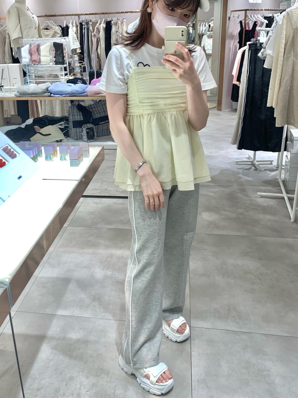 ホワイト系のTシャツ/カットソー、ホワイト系のサンダル、イエロー系のキャミソールを着用したレディースの春コーディネートの4枚目の写真