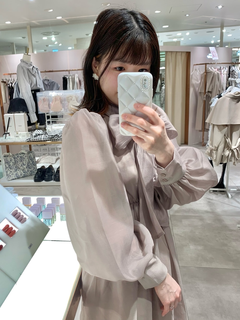 ベージュ系のトレンチコート、ホワイト系のサンダル、ホワイト系のボディバッグ/ウエストポーチを着用したレディースの春コーディネートの7枚目の写真