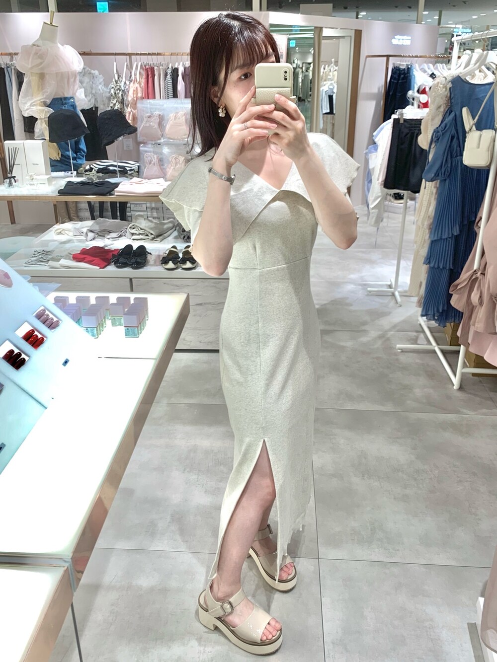 ベージュ系のワンピース、ホワイト系のボストンバッグ、ベージュ系のサンダルを着用したレディースの春コーディネートの3枚目の写真