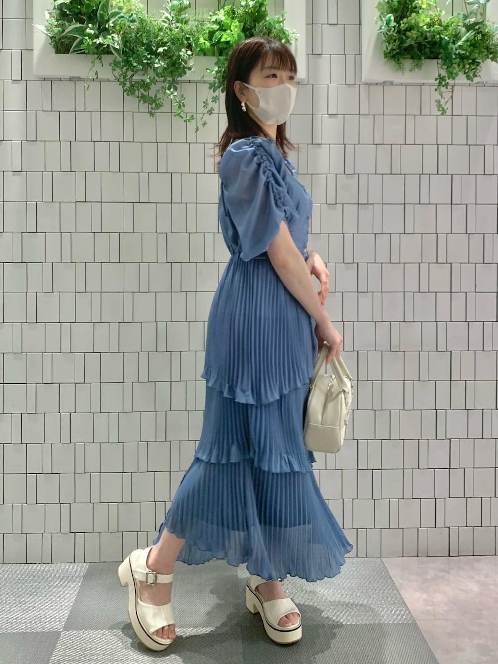 ホワイト系のサンダル、ホワイト系のボストンバッグ、ブルー系のワンピースを着用したレディースの春コーディネートの9枚目の写真