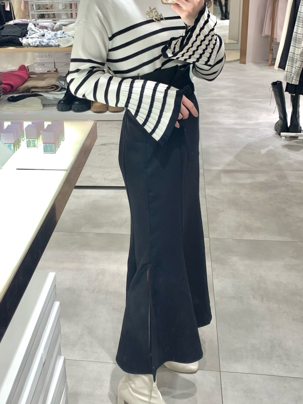 ホワイト系のトートバッグ、ブラック系のスカート、ホワイト系のニット/セーターを着用したレディースの春コーディネートの3枚目の写真