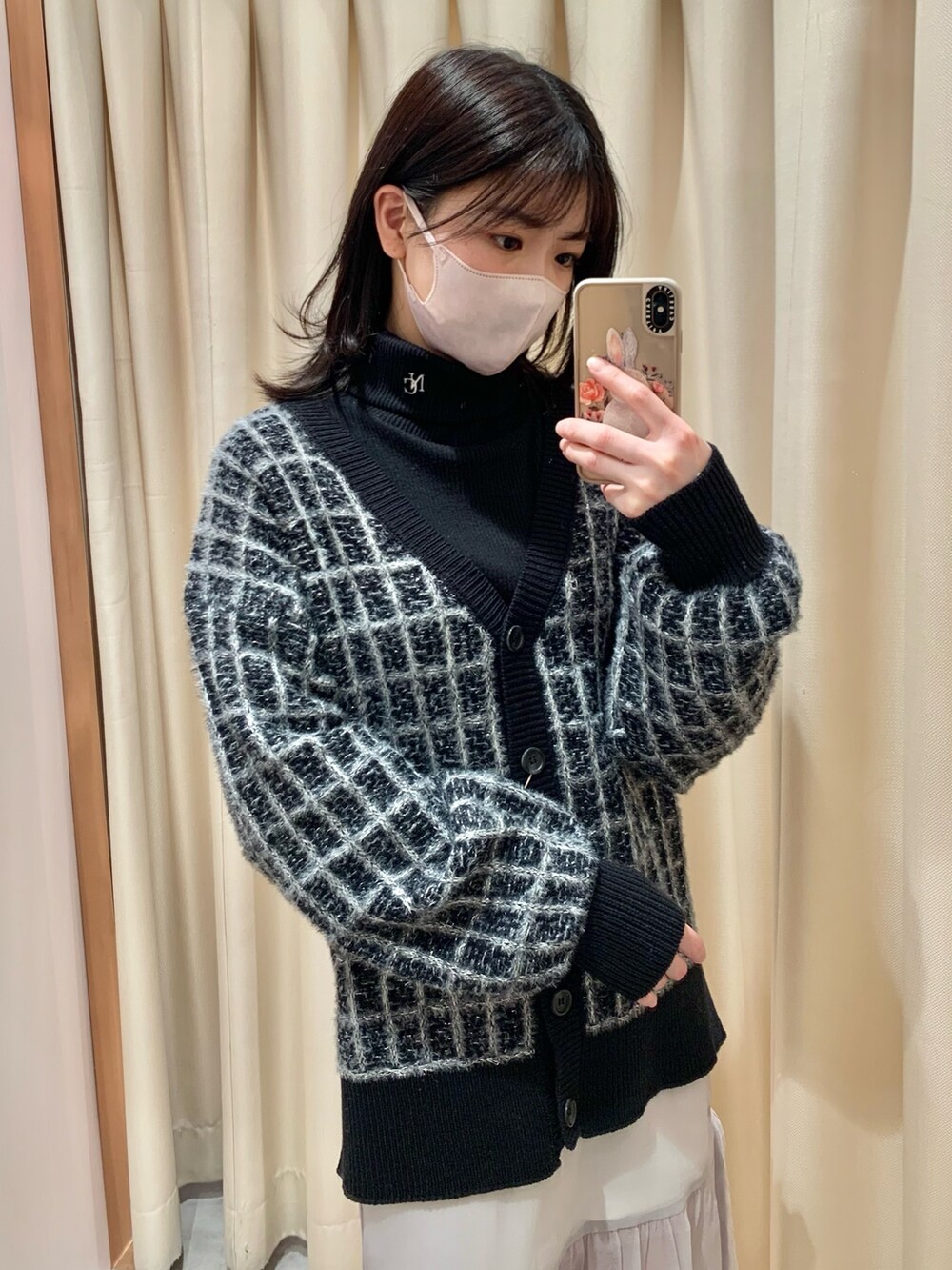 ブラック系のカーディガン/ボレロ、グレー系のスカート、ブラック系のブーツを着用したレディースの冬コーディネートの3枚目の写真