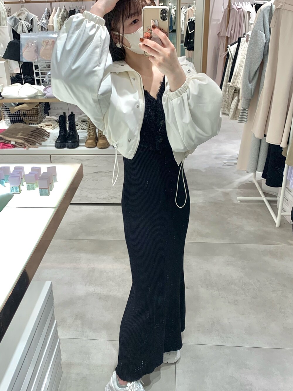 ホワイト系のマウンテンパーカー、ブラック系のワンピース、ホワイト系のスニーカーを着用したレディースの春コーディネートの3枚目の写真