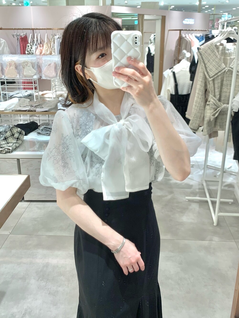 ベージュ系のトレンチコート、ホワイト系のシャツ/ブラウス、ブラック系のショルダーバッグを着用したレディースの春コーディネートの5枚目の写真