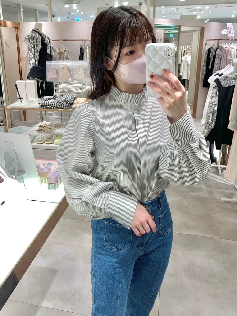 ベージュ系のトレンチコート、グレー系のブーツ、ブルー系のデニムパンツを着用したレディースの春コーディネートの8枚目の写真