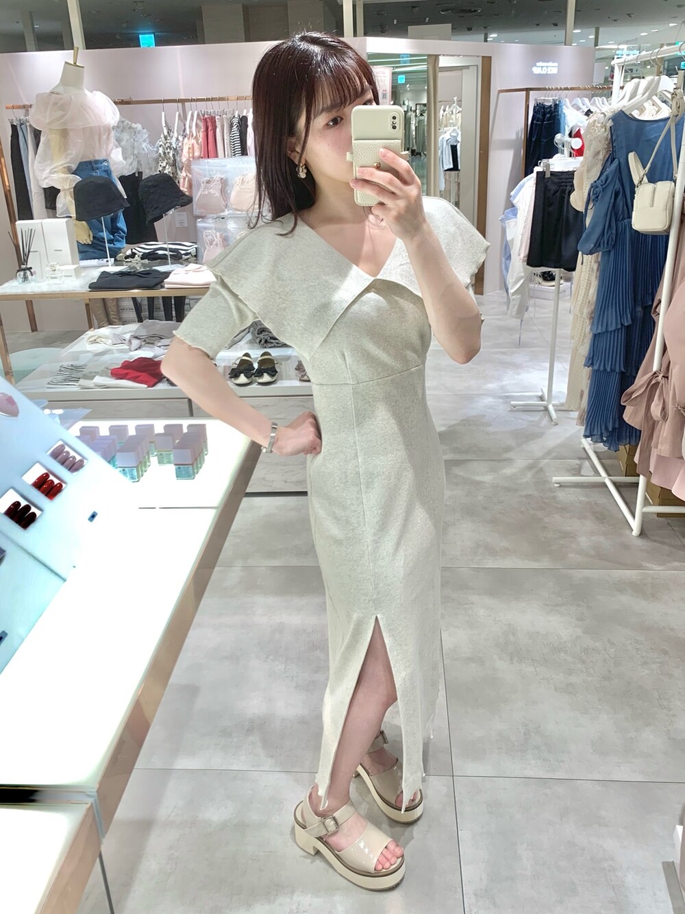 ベージュ系のワンピース、ホワイト系のボストンバッグ、ベージュ系のサンダルを着用したレディースの春コーディネートの4枚目の写真