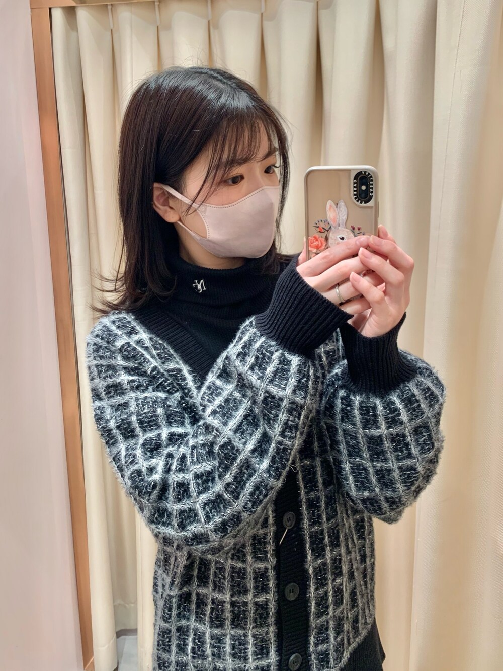 ブラック系のカーディガン/ボレロ、グレー系のスカート、ブラック系のブーツを着用したレディースの冬コーディネートの2枚目の写真