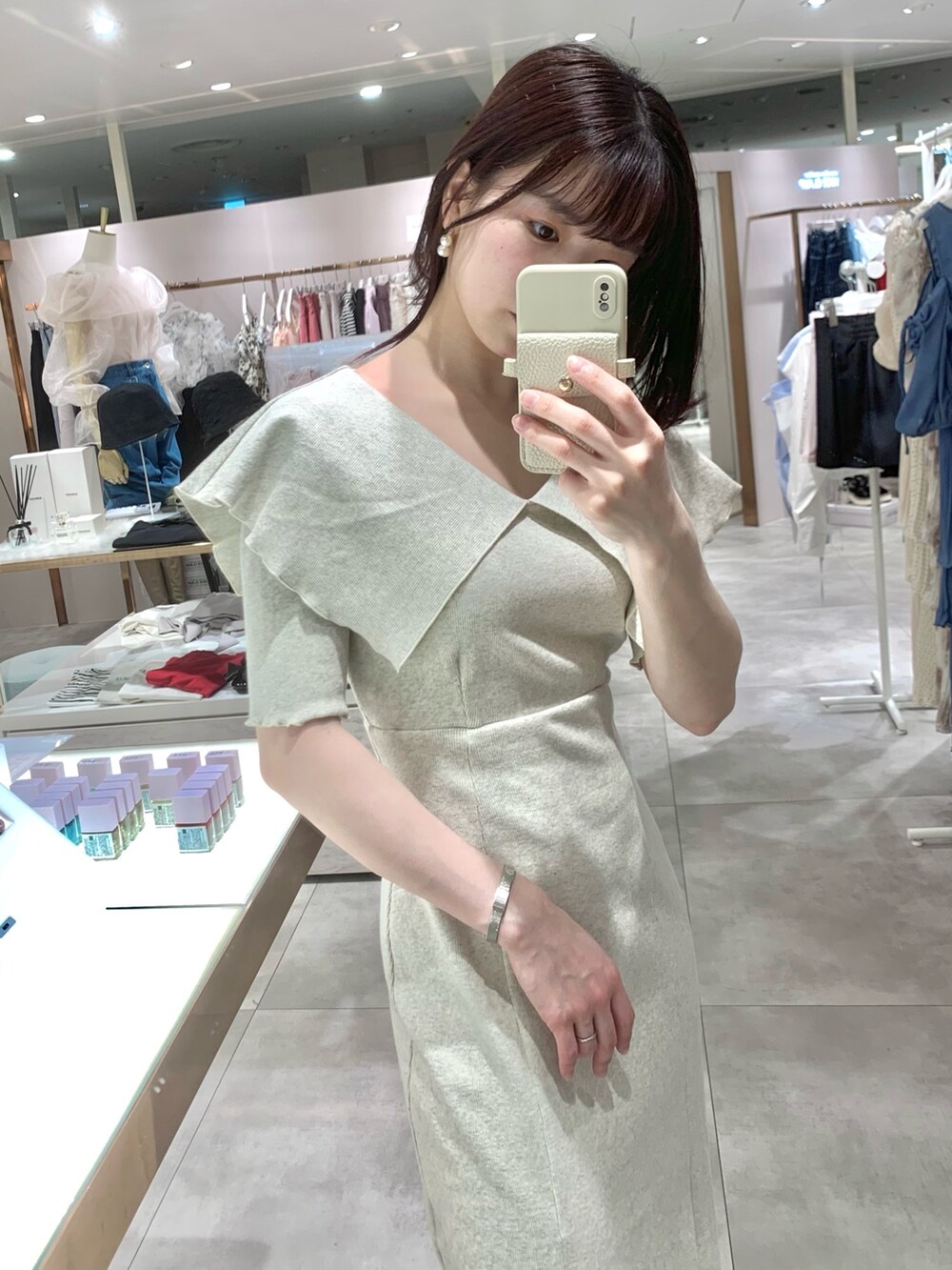 ベージュ系のワンピース、ホワイト系のボストンバッグ、ベージュ系のサンダルを着用したレディースの春コーディネートの5枚目の写真