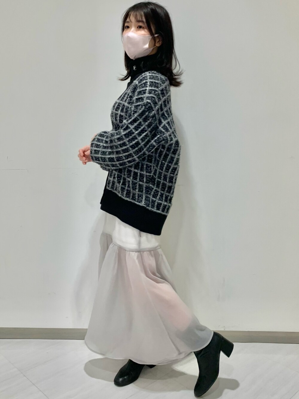 ブラック系のカーディガン/ボレロ、グレー系のスカート、ブラック系のブーツを着用したレディースの冬コーディネートの5枚目の写真