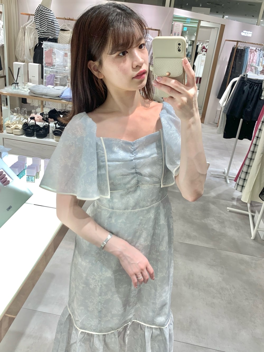 ホワイト系のショルダーバッグ、グレー系のワンピース、ホワイト系のサンダルを着用したレディースの夏コーディネートの4枚目の写真